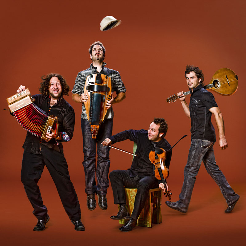 Le Vent du Nord : les quatre musiciens et leurs instruments sur fond orangé